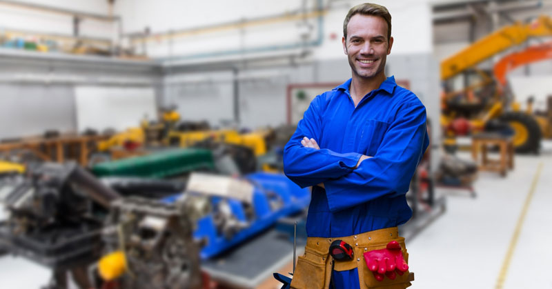 Homme se tenant debout derrière une usine de fabrication de métal