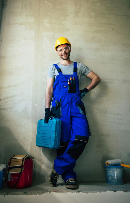 Homme debout qui tiens un coffre à outils